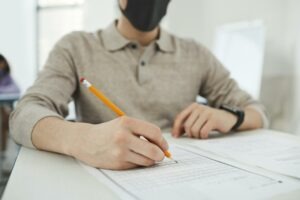 Texte alternatif (alt) : Candidate annotant un dossier de concours avec un stylo rouge — préparation épreuves attaché territorial 2026