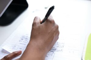 personne qui écrit sur une feuille de préparation pour ses concours